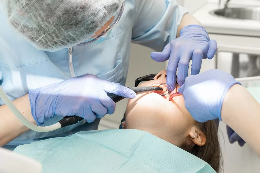 An oral surgery patient being treated, with the dentist performing a procedure to address dental issues or implants.