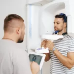 Young man inside a 3D dental CBCT scanner enabling precise surgical planning and diagnostics.
