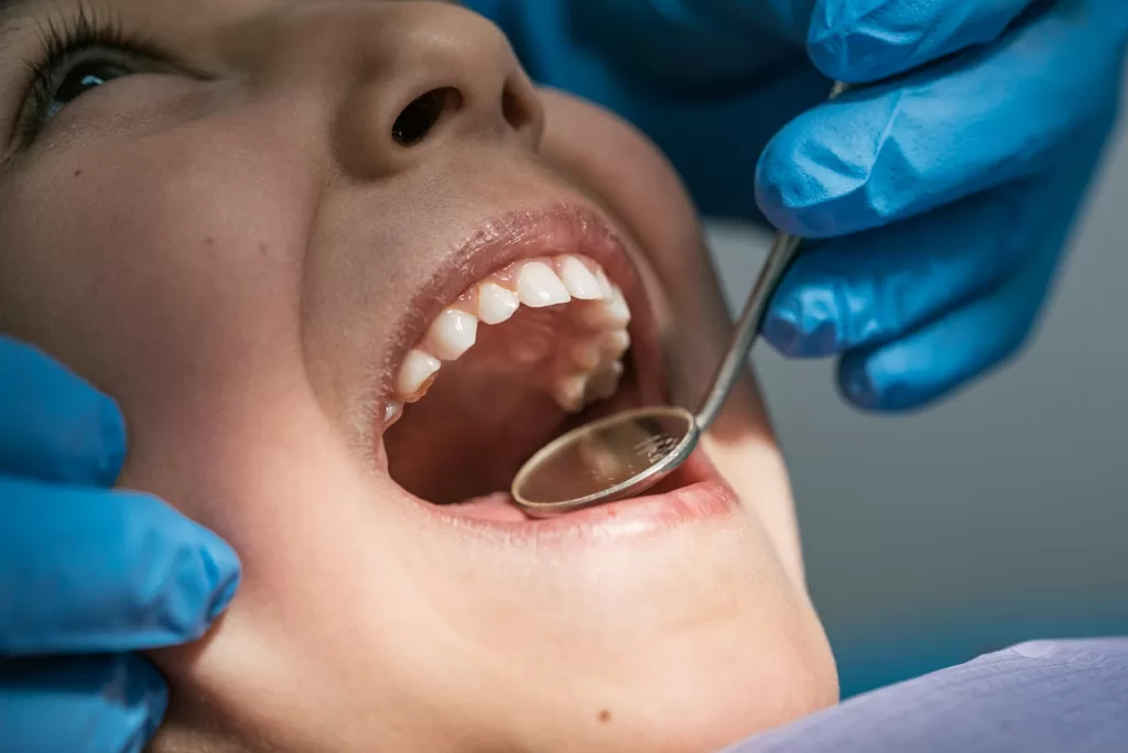 A dentist treats a patient's teeth, using professional tools in a dental procedure for oral care and treatment.