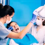 Dentist and nurse performing wisdom teeth extraction procedure on a patient in a New Jersey oral surgery clinic.