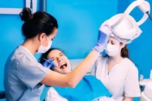 Dentist and nurse performing wisdom teeth extraction procedure on a patient in a New Jersey oral surgery clinic.