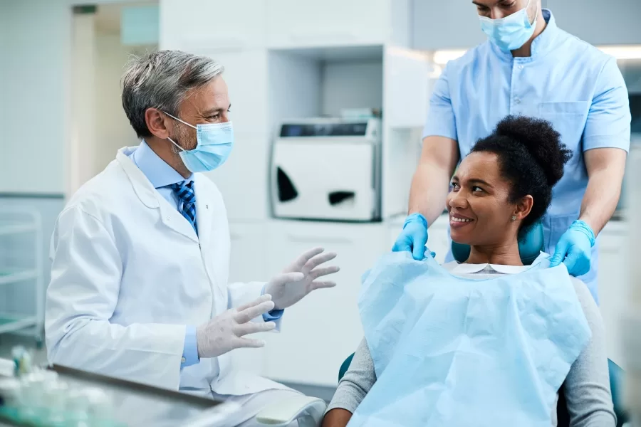 Woman smiling and discussing wisdom teeth surgery preparation with her dentist at Ridge Oral Surgery in New Jersey.