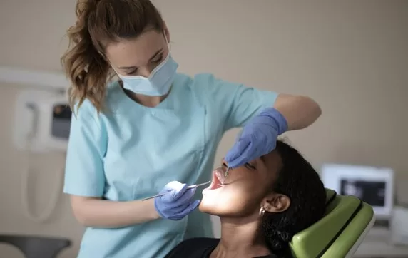 A dentist performing an oral surgery procedure on a patient at Ridge Oral Surgery in a modern treatment room.