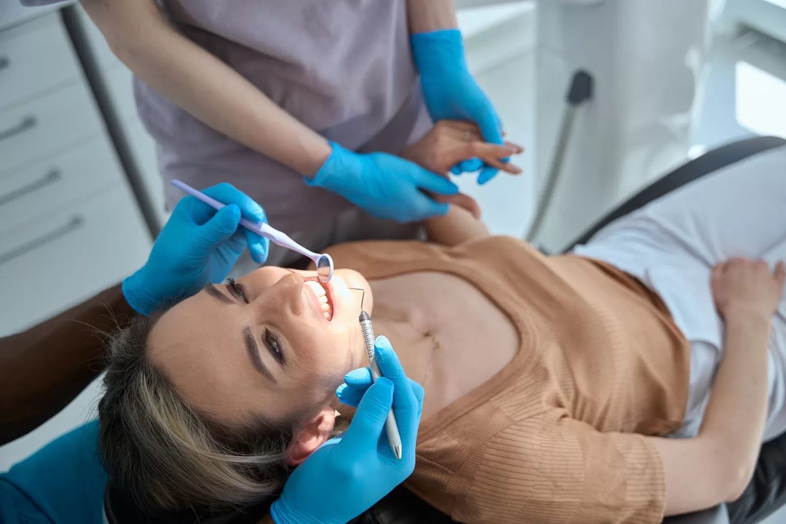 A lady undergoing a teeth whitening procedure and she seems very happy about it. 