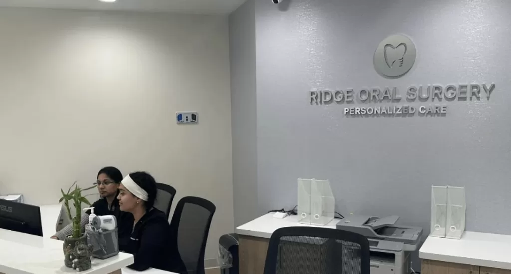 A reception area at a dentist's office labeled "Ridge Oral Surgery: Personalized Care," with staff seated at the front desk.