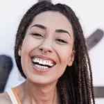 A smiling woman showing healthy gums and promoting awareness about gum disease prevention.