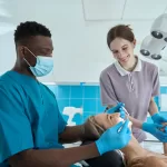 two people helping with the teeth whitening of a lady