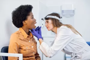 Doctor examining a patient’s mouth for potential oral biopsies.