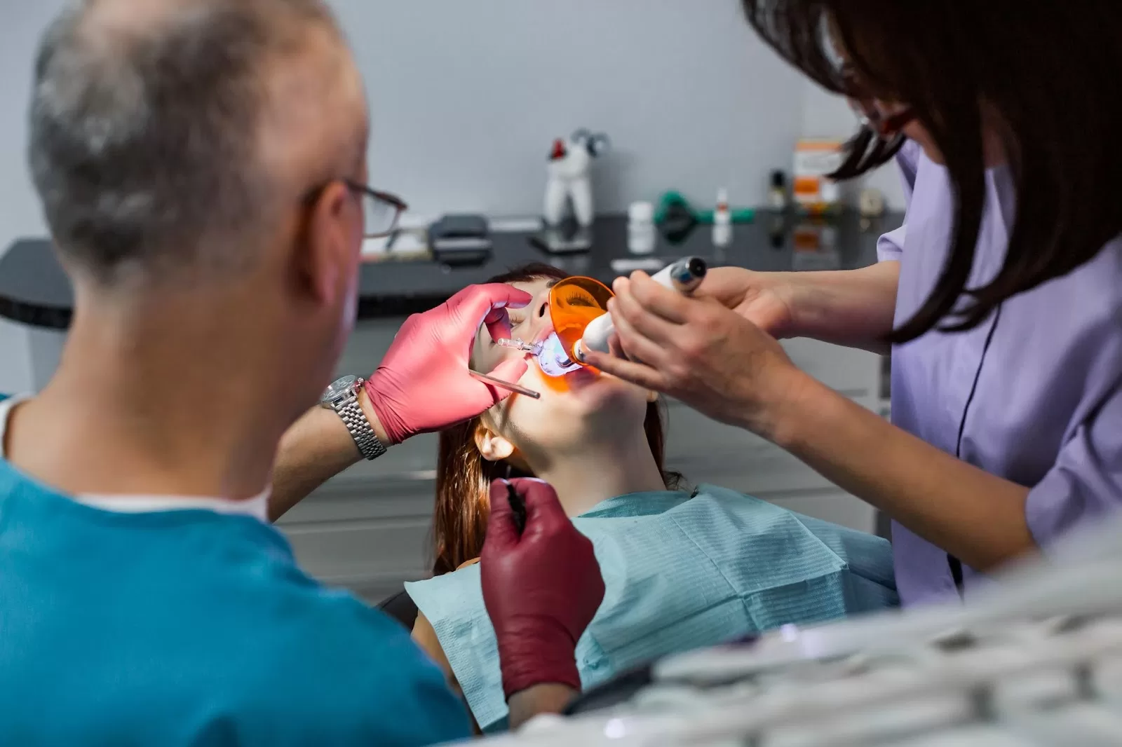 Dentists performing a procedure on a patient, addressing a dental emergency in a modern clinic setting."