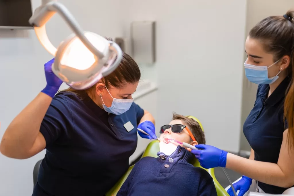 Child receiving professional oral care at the dentist with a thorough dental examination.