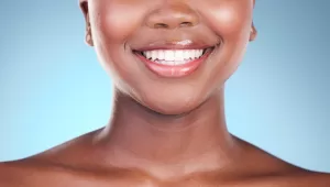 A face showcasing features from modern nose and down, till the collarbones, against a sky blue backdrop.