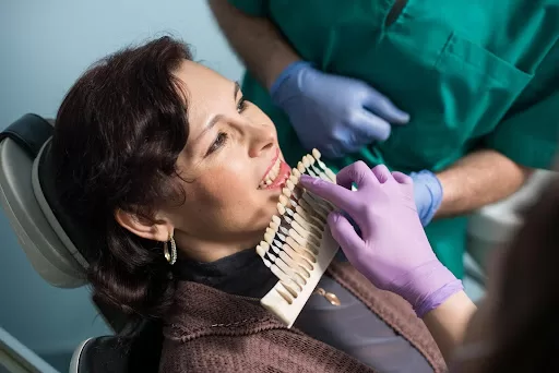 Dentist with assistant, choosing the right dental implant for “smile in a day” procedure for a patient