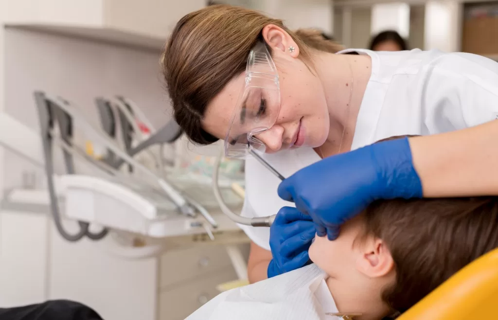 Shot of a dentist inspecting a child’s teeth.