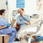 Medical nurse examining a patient with a toothache at the dentist's clinic.