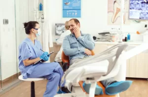 Medical nurse examining a patient with a toothache at the dentist's clinic.