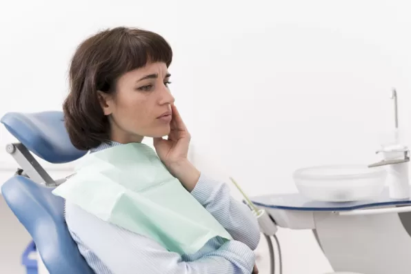 A female patient having a toothache at the dentist's office. 