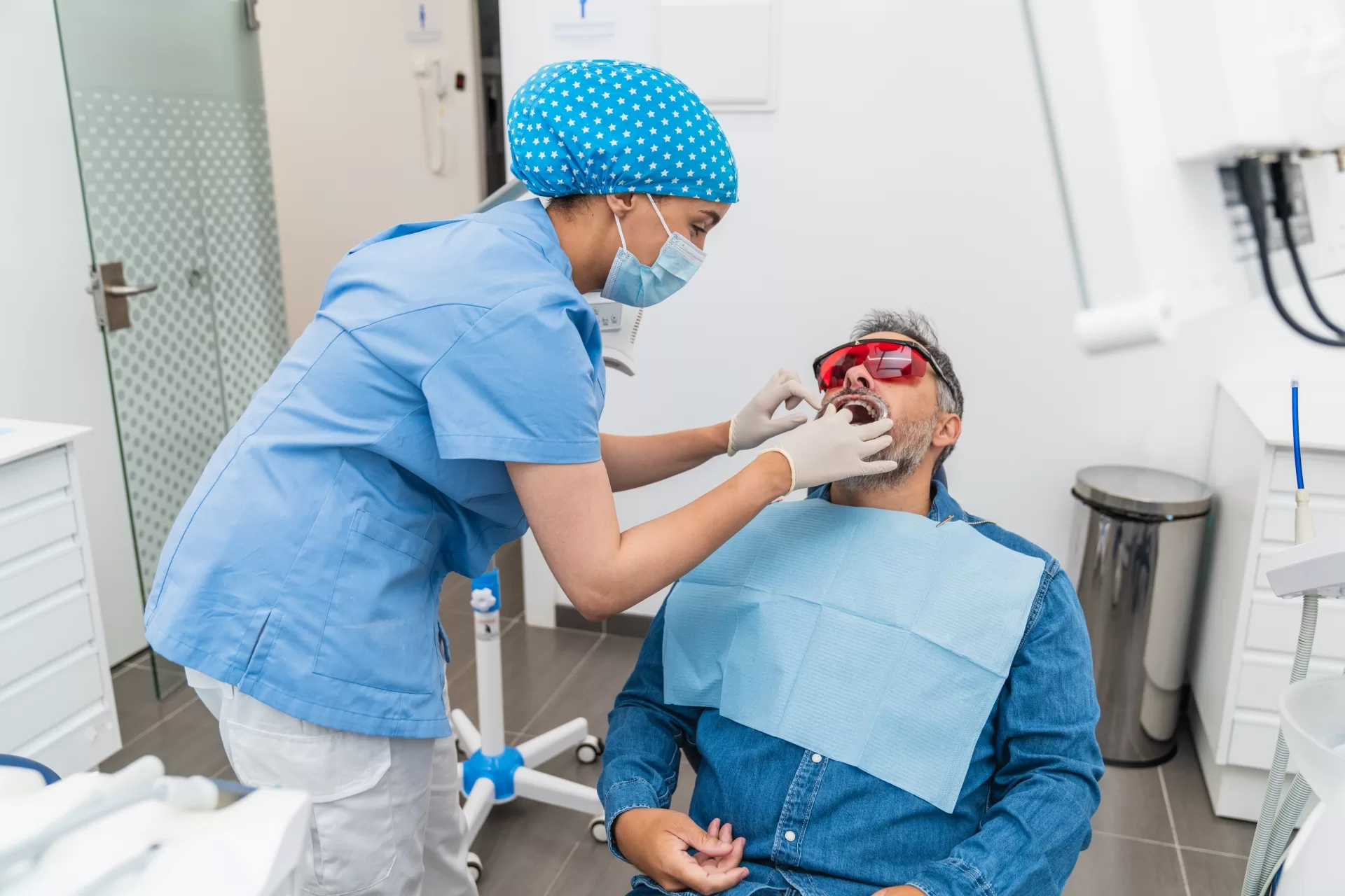 Medical nurse examining a patient with a toothache at the dentist's clinic.