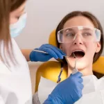 Image of a dentist checking a patient’s mouth for oral well-being.