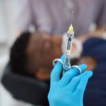 Dentist holding a sterile syringe with dental anesthetic before an oral surgery procedure at Ridge Oral Surgery clinic.