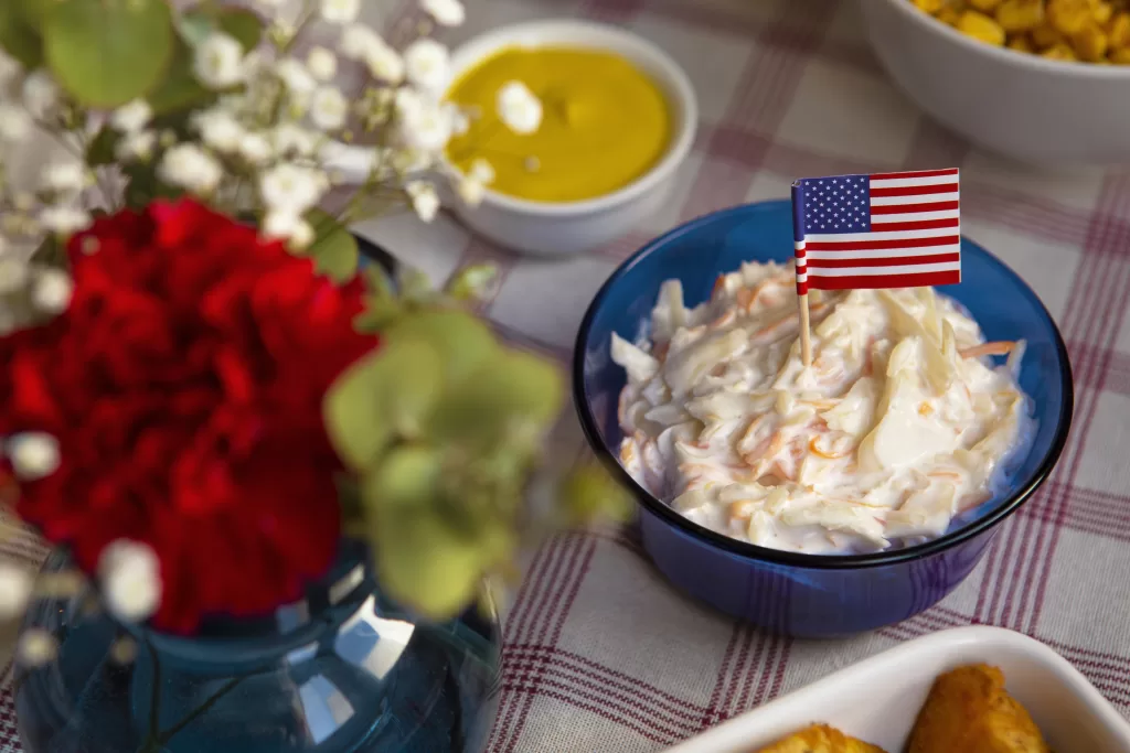 Patriotic July 4 food display featuring mashed potatoes and soft dishes with a miniature American flag.