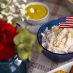 Patriotic July 4 food display featuring mashed potatoes and soft dishes with a miniature American flag.