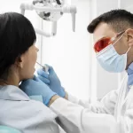 A dentist performing a dental check-up on a patient in a clinic.