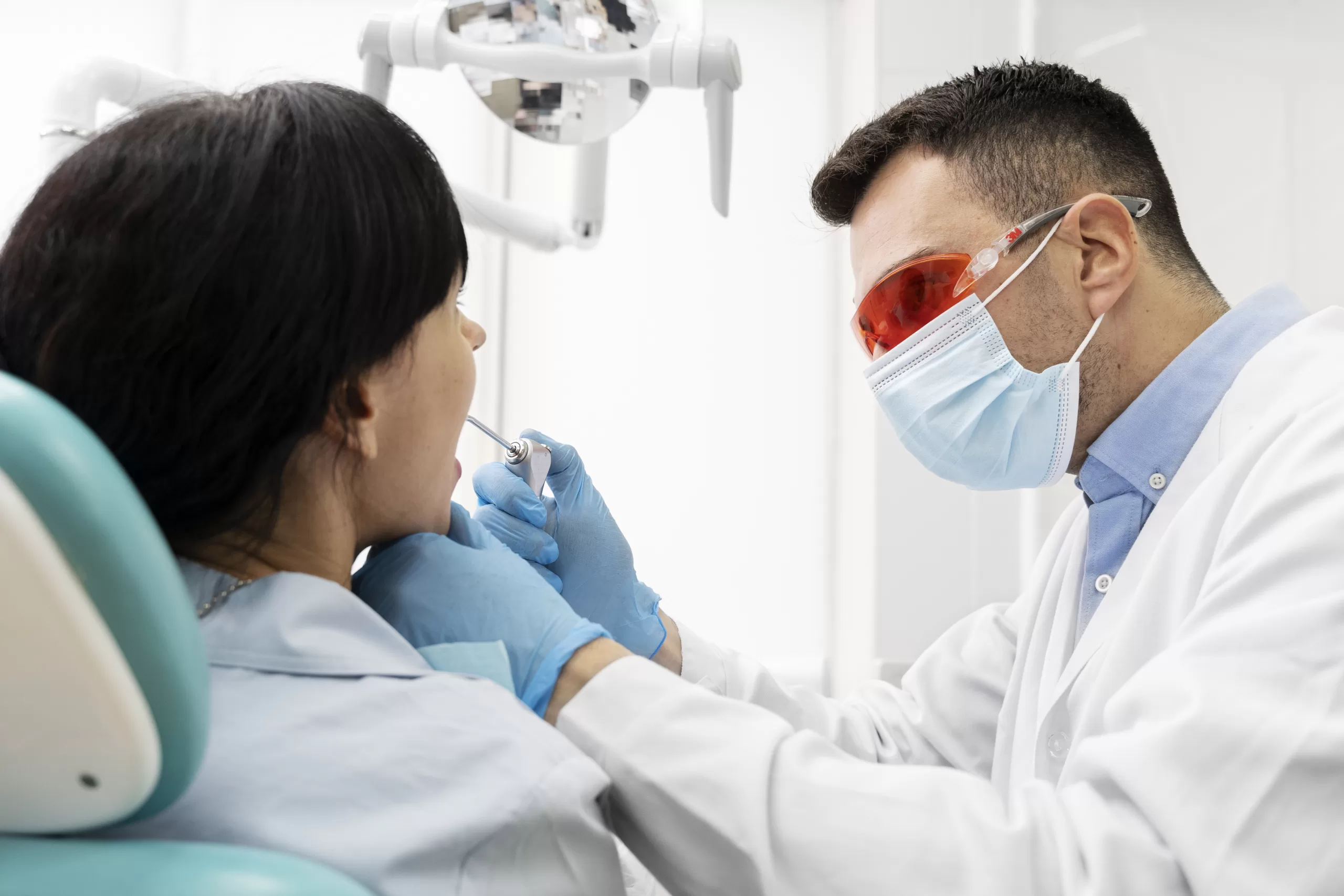 A dentist performing a dental check-up on a patient in a clinic.