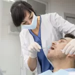 A dentist examines a male patient’s mouth during a dental check-up at the Ridge Oral Surgery and Dental Implants clinic.