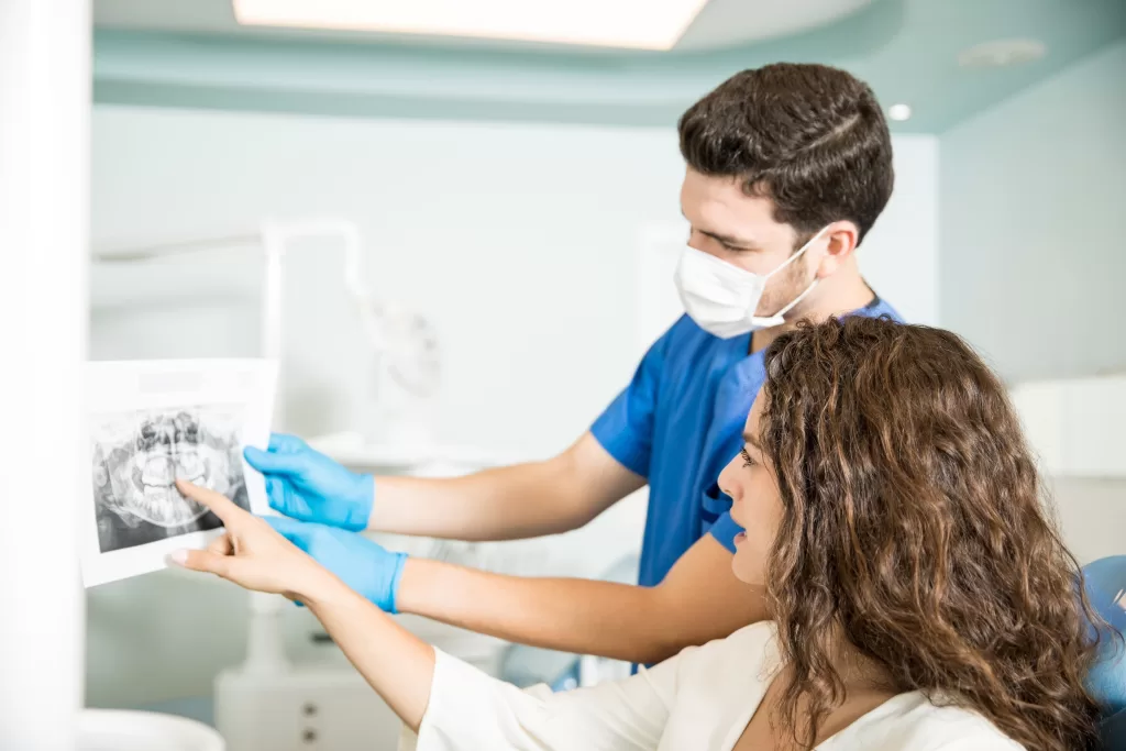 A dentist showing the X-ray of teeth to a patient at the Ridge Oral Surgery clinic.