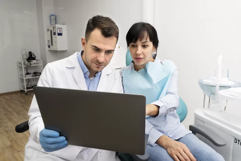 A dentist explaining a procedure to a patient at the Ridge Oral Surgery clinic.