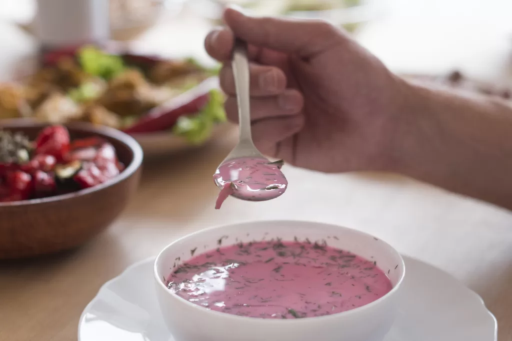 A close-up shot of a person holding a spoonful of soup.