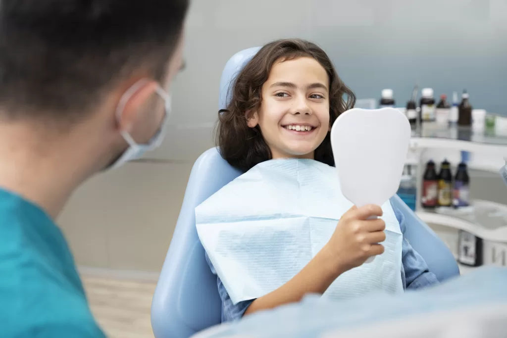 A boy smiling at the dentist at the Ridge Oral Surgery clinic.