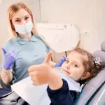 A dentist and a girl showing thumbs up at the Ridge Oral Surgery clinic.