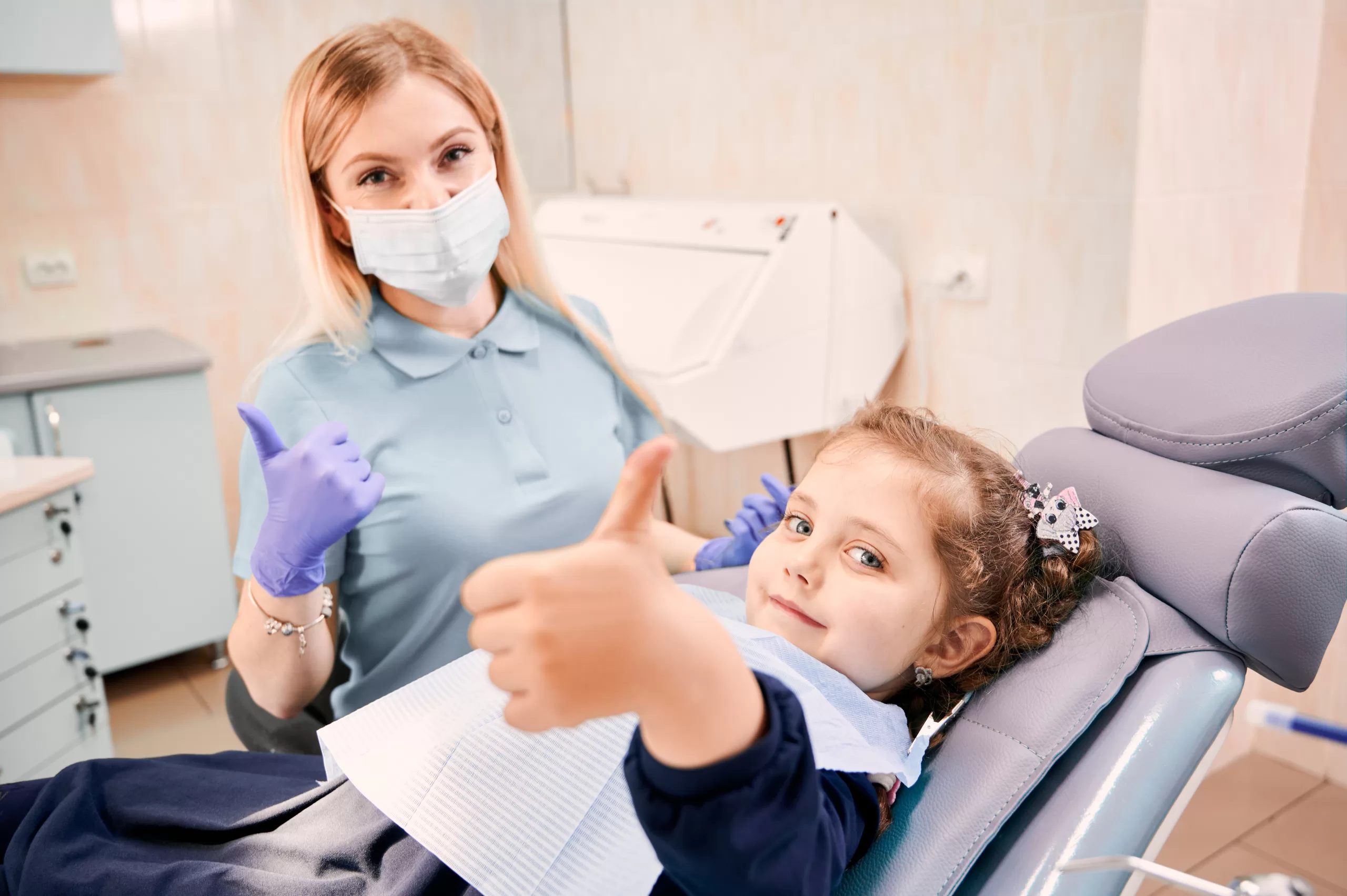 A dentist and a girl showing thumbs up at the Ridge Oral Surgery clinic.