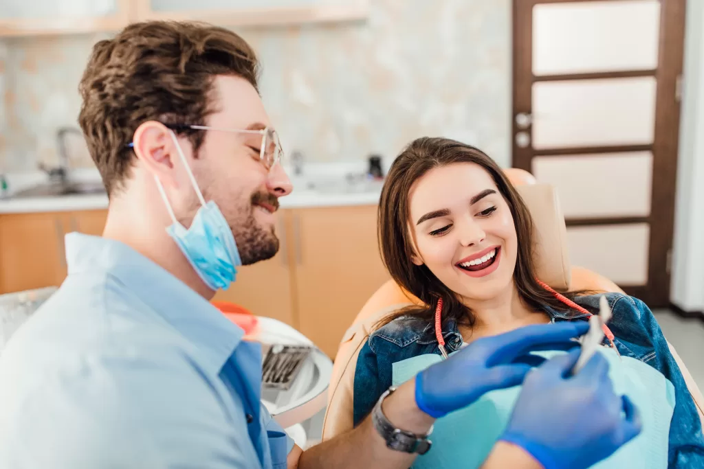 Dentist matching the color of the tooth enamel with the whitening chart at the Ridge Oral Surgery clinic.