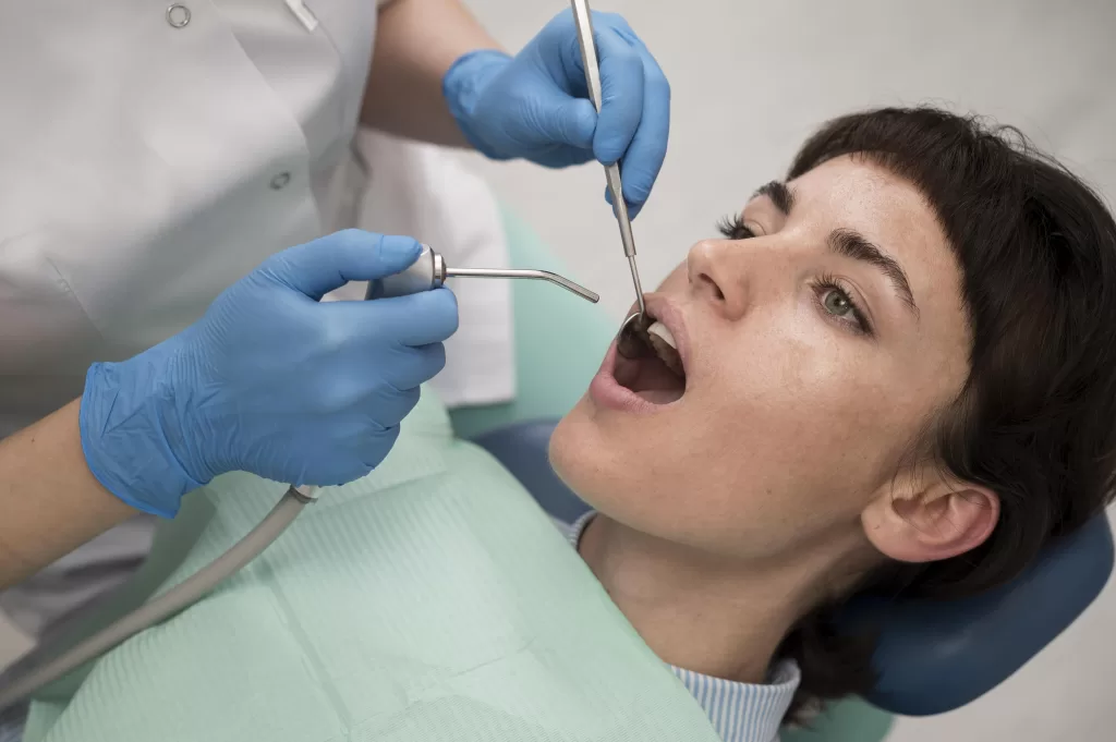 Young female patient undergoing a dental procedure at Ridge Oral Surgery, with dentist using precision tools.