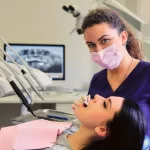 A dentist at Ridge Oral Surgery examining a woman’s oral health during a dental appointment.