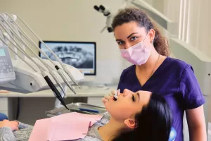 A dentist at Ridge Oral Surgery examining a woman’s oral health during a dental appointment.