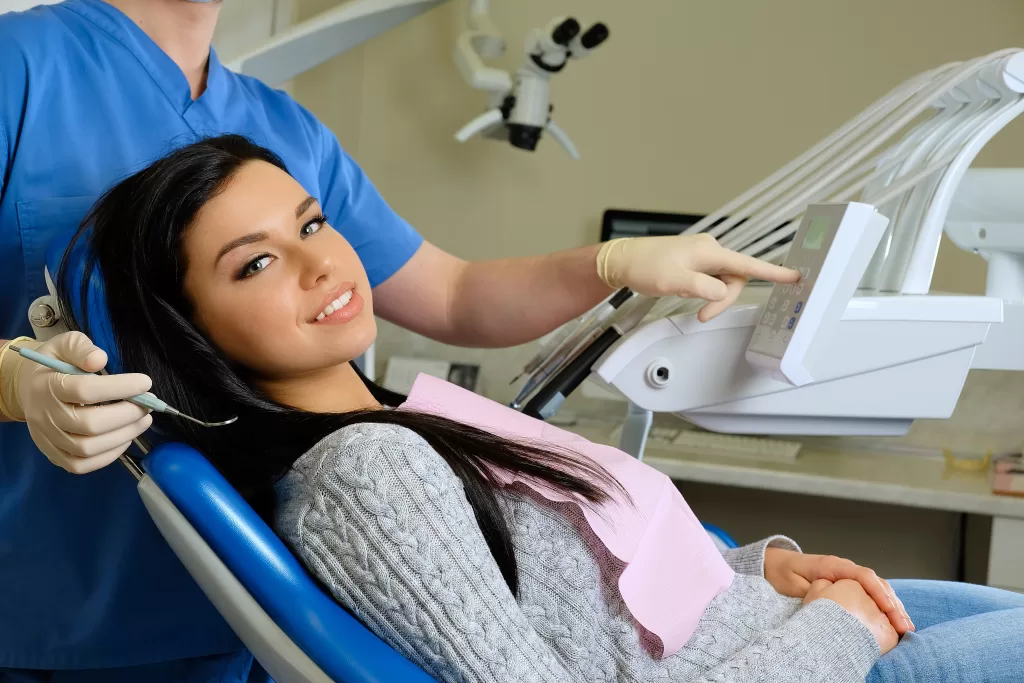 A dentist using professional tools while treating a female patient at Ridge Oral Surgery.