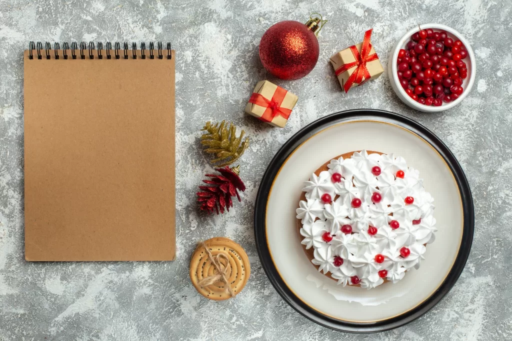Christmas desserts and festive treats displayed on a table, with a cake, cranberries, and presents.