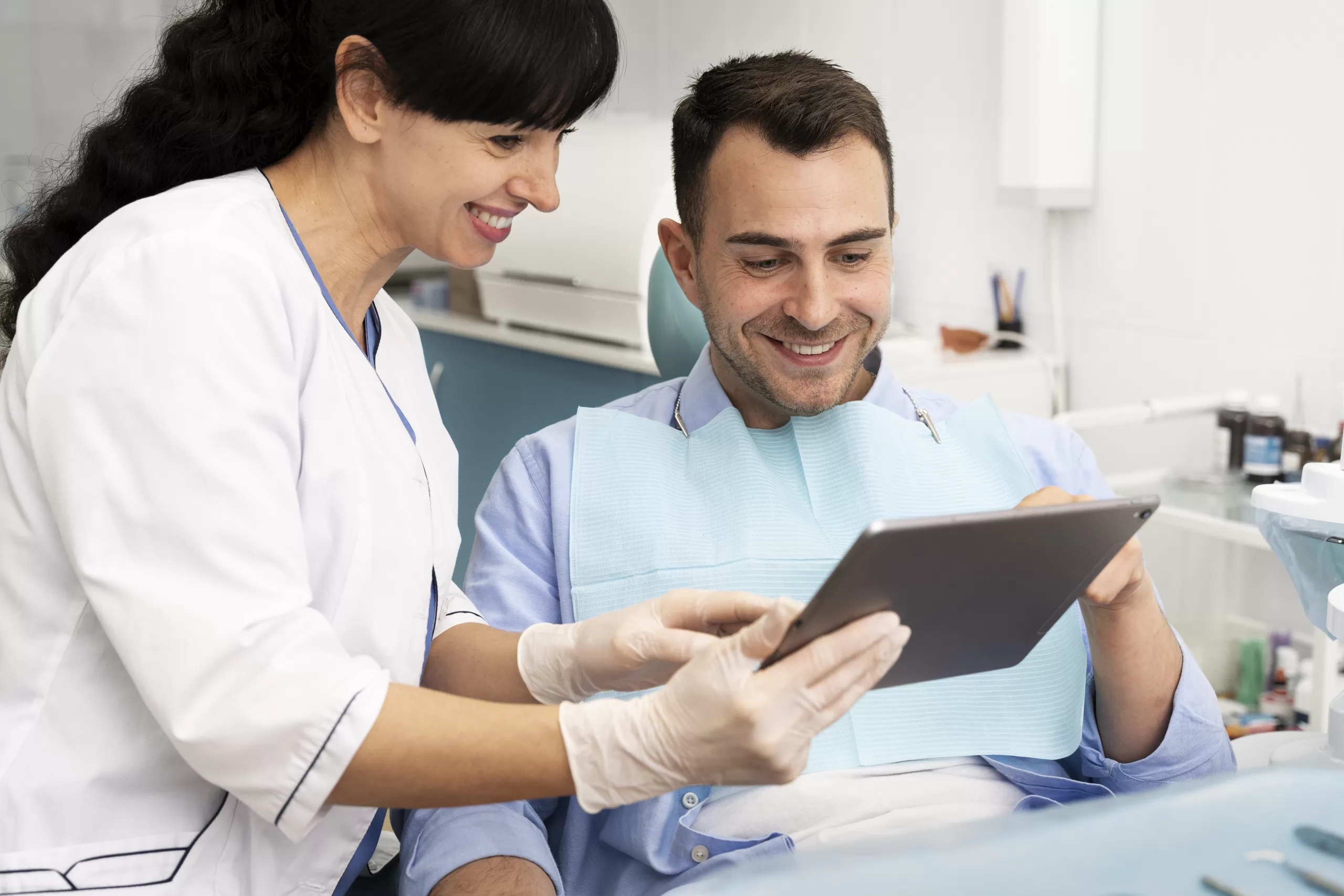 Oral surgeon reviewing a digital medical chart with a patient during treatment planning at Ridge Oral Surgery clinic.