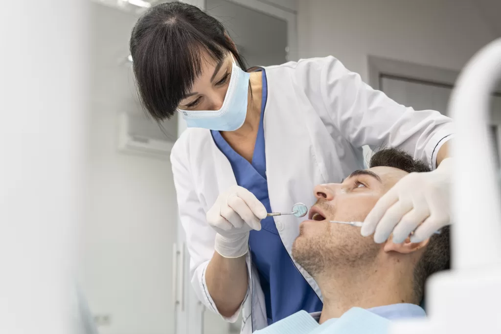 Dentist performing a dental check-up on a patient at Ridge Oral Surgery clinic.