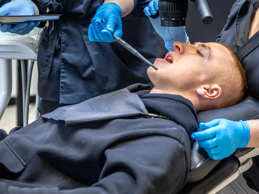 A patient lying in a chair and being treated by the dentist at the Ridge Oral Surgery clinic.