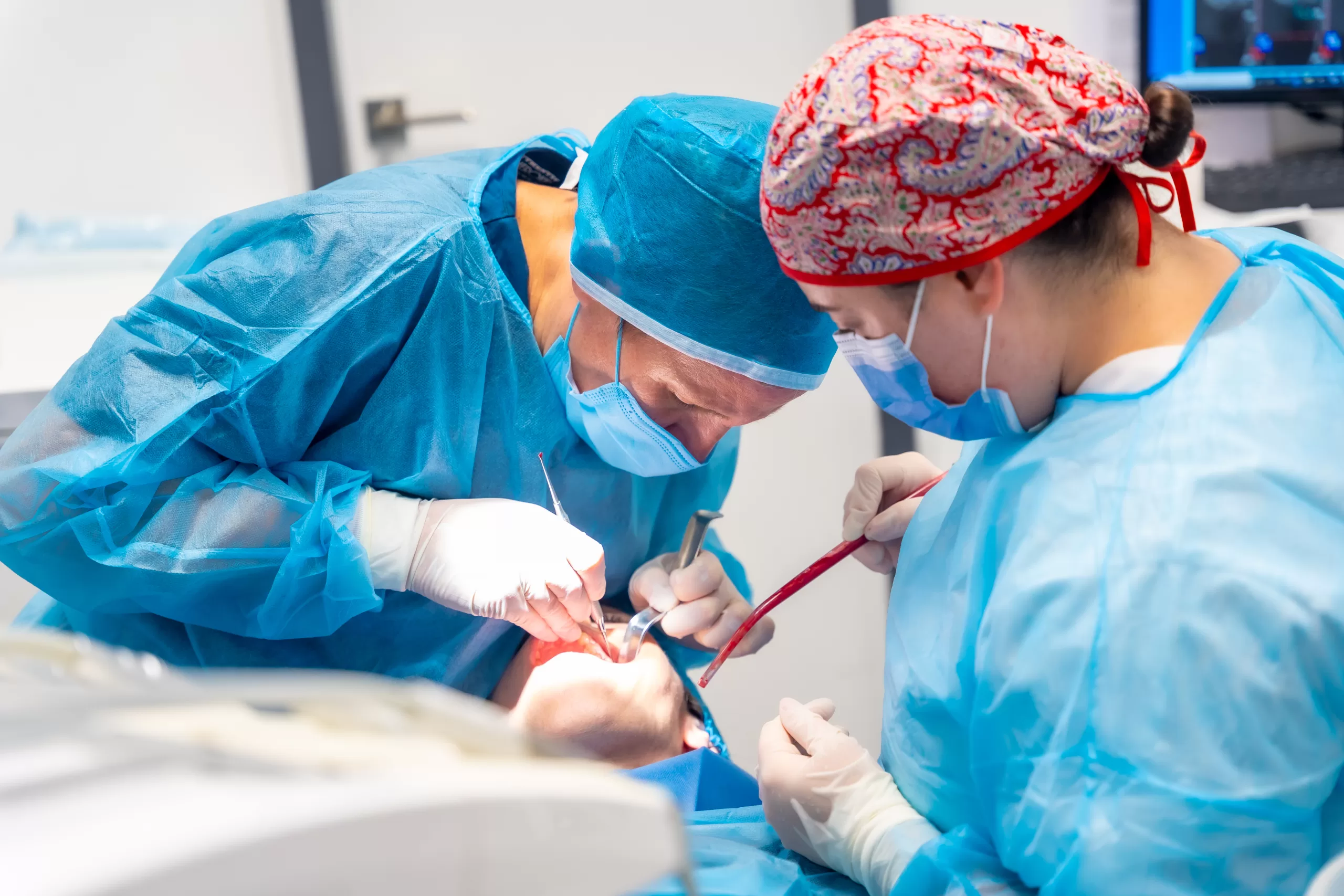 Dental surgeon performing a tooth extraction during a clinical procedure, illustrating professional oral surgery care.