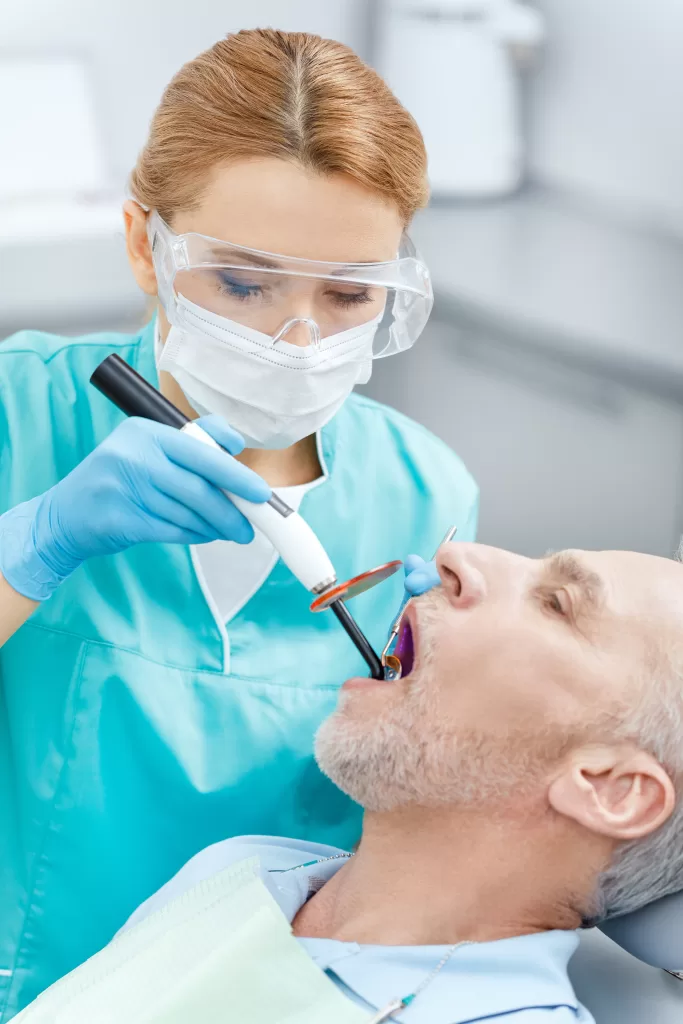 ental surgeon providing in-chair treatment to a patient during a clinical procedure.