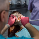 Young woman patient receiving a dental implant check-up at Ridge Oral Surgery clinic during a professional dental examination.