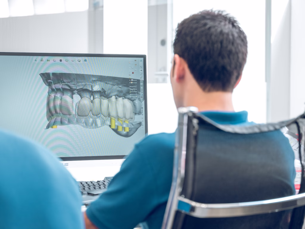 Dentist reviewing a digital 3D dental scan for full-mouth implant treatment planning at Ridge Oral Surgery.