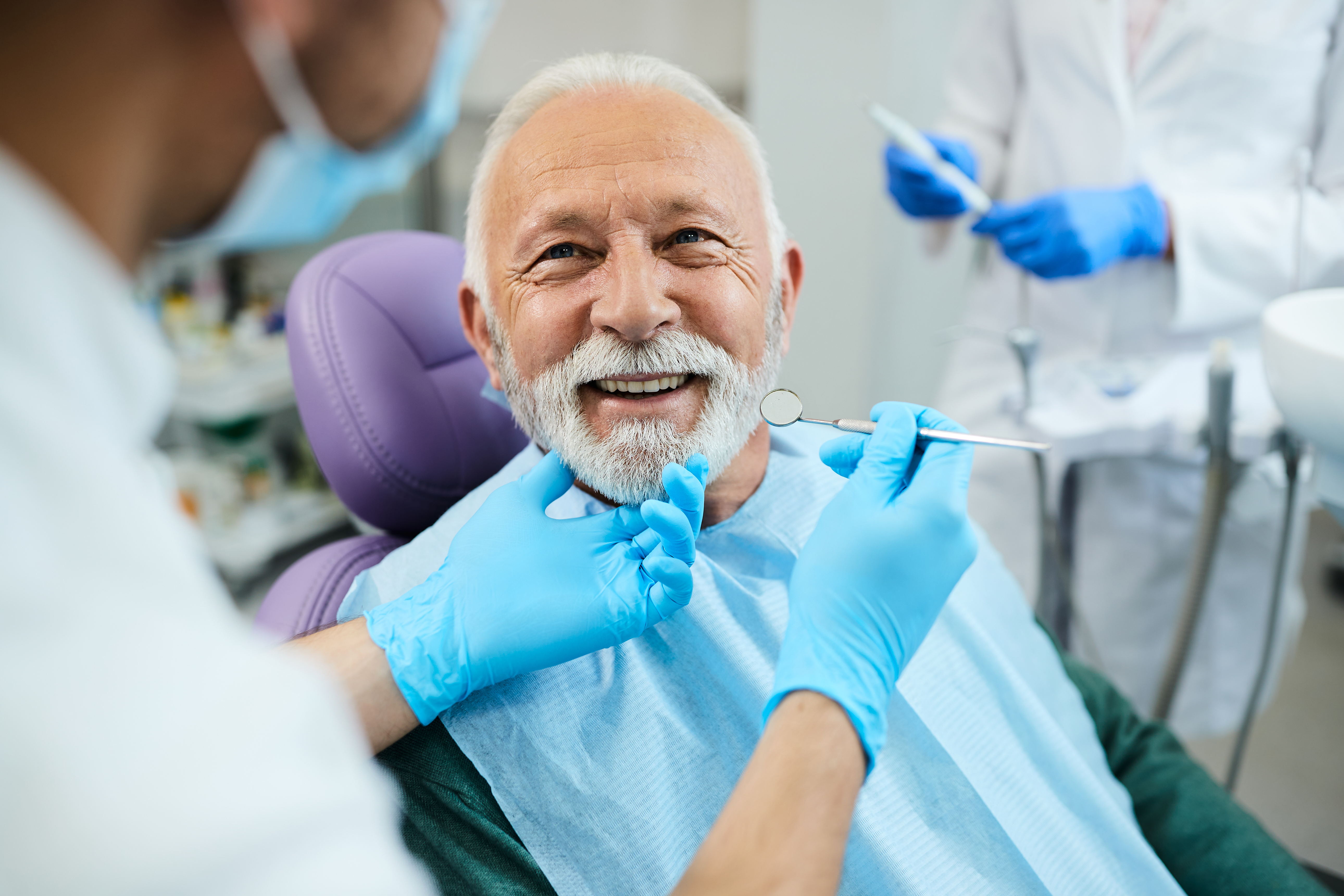 Male patient smiling during dental implant treatment at an oral surgery clinic.
