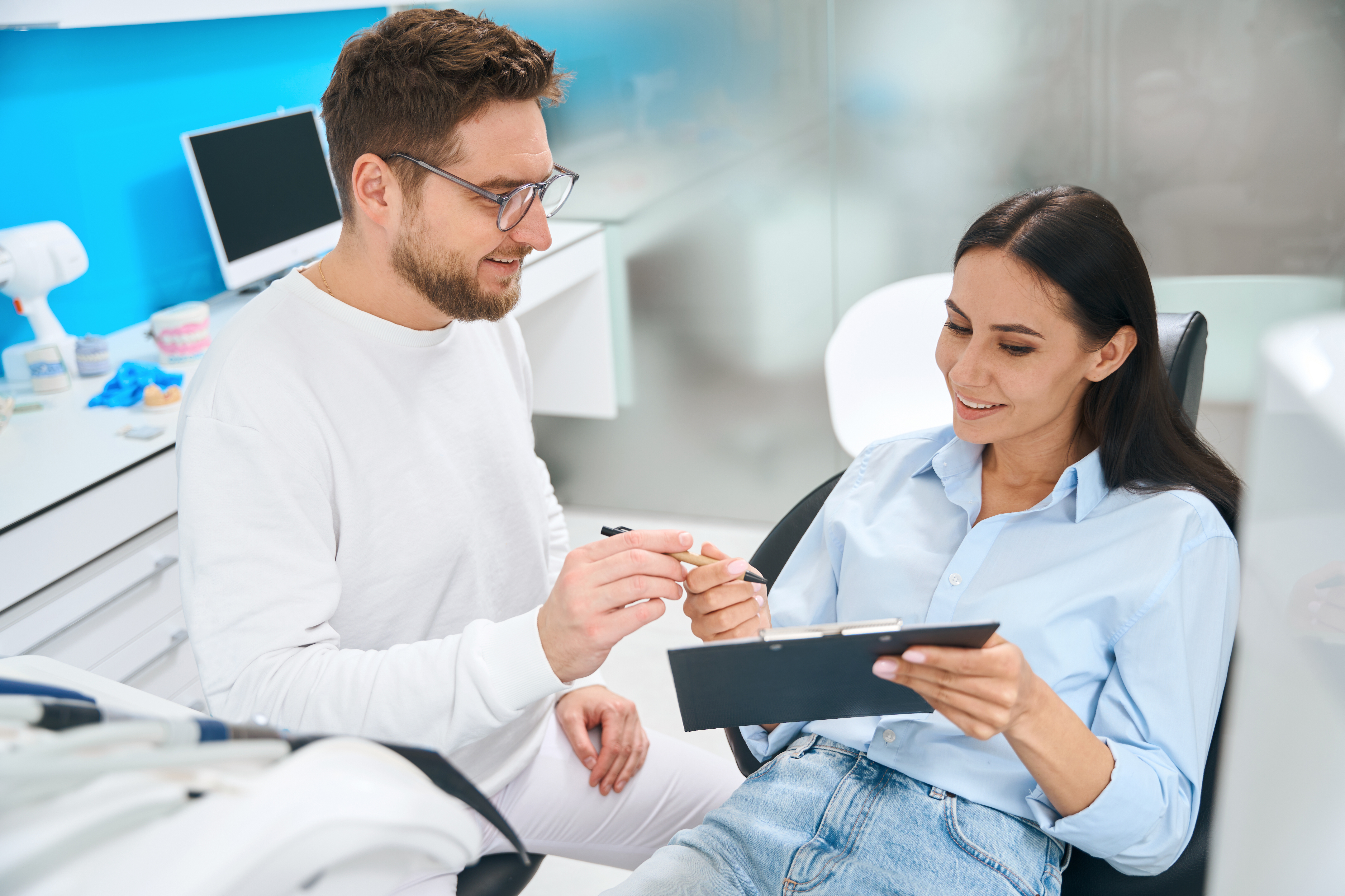 Patient consulting with a dentist about full-mouth dental implant costs during a clinic visit.