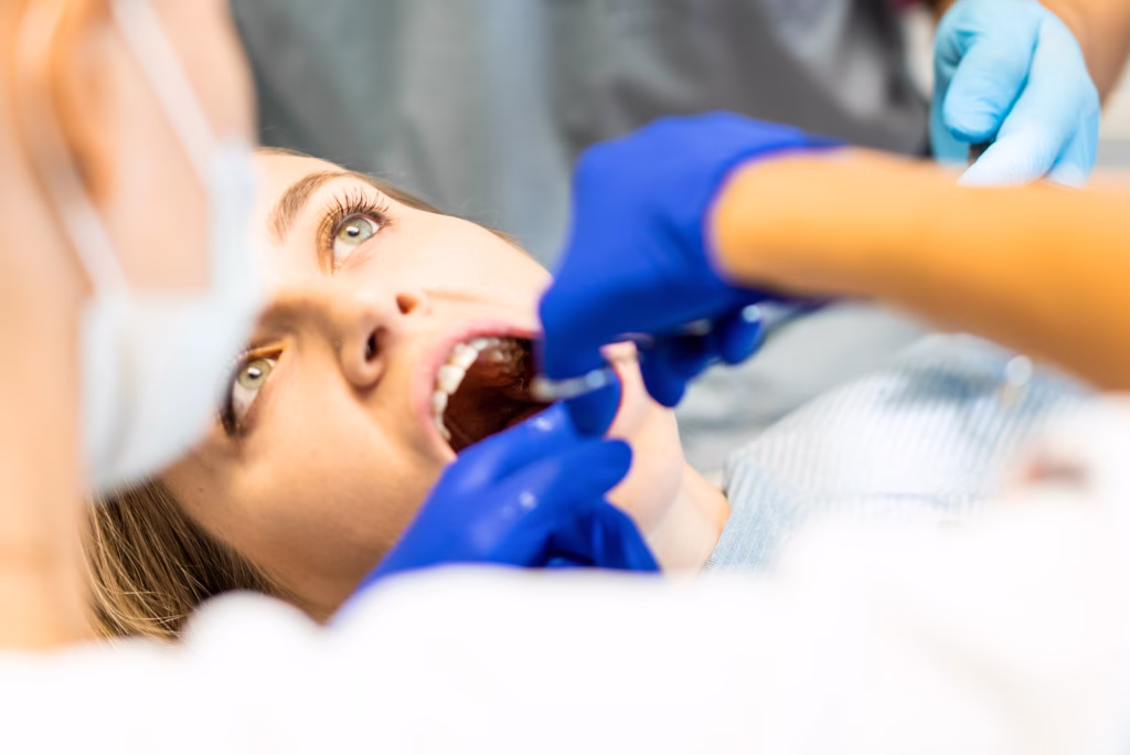 Oral surgeon performing an emergency dental exam to evaluate a painful tooth and determine whether extraction is necessary.